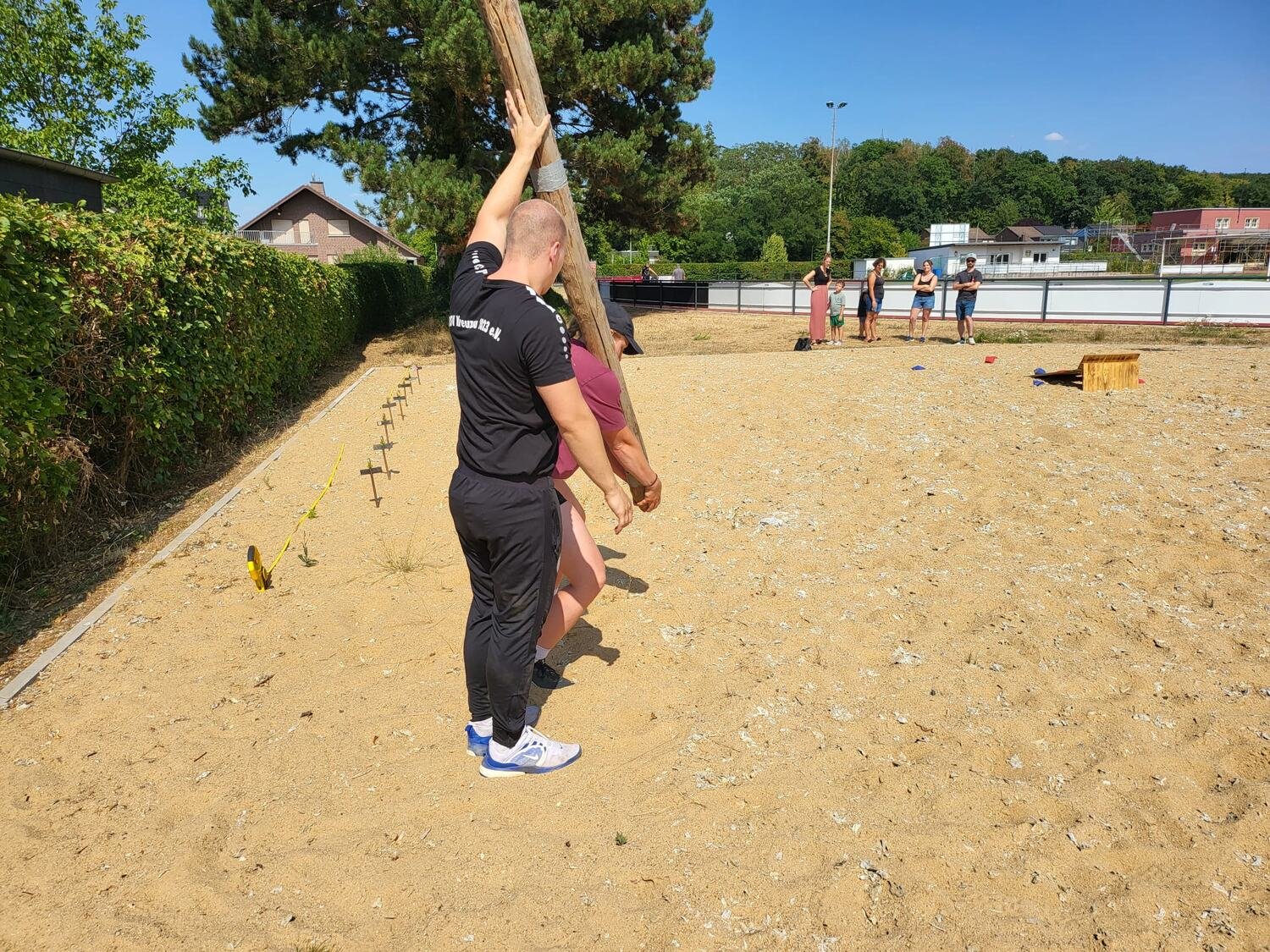 Caber Toss — ein Sportler des BSV Kreuzau richtet gemeinsam mit einem Helfer den Baumstamm auf