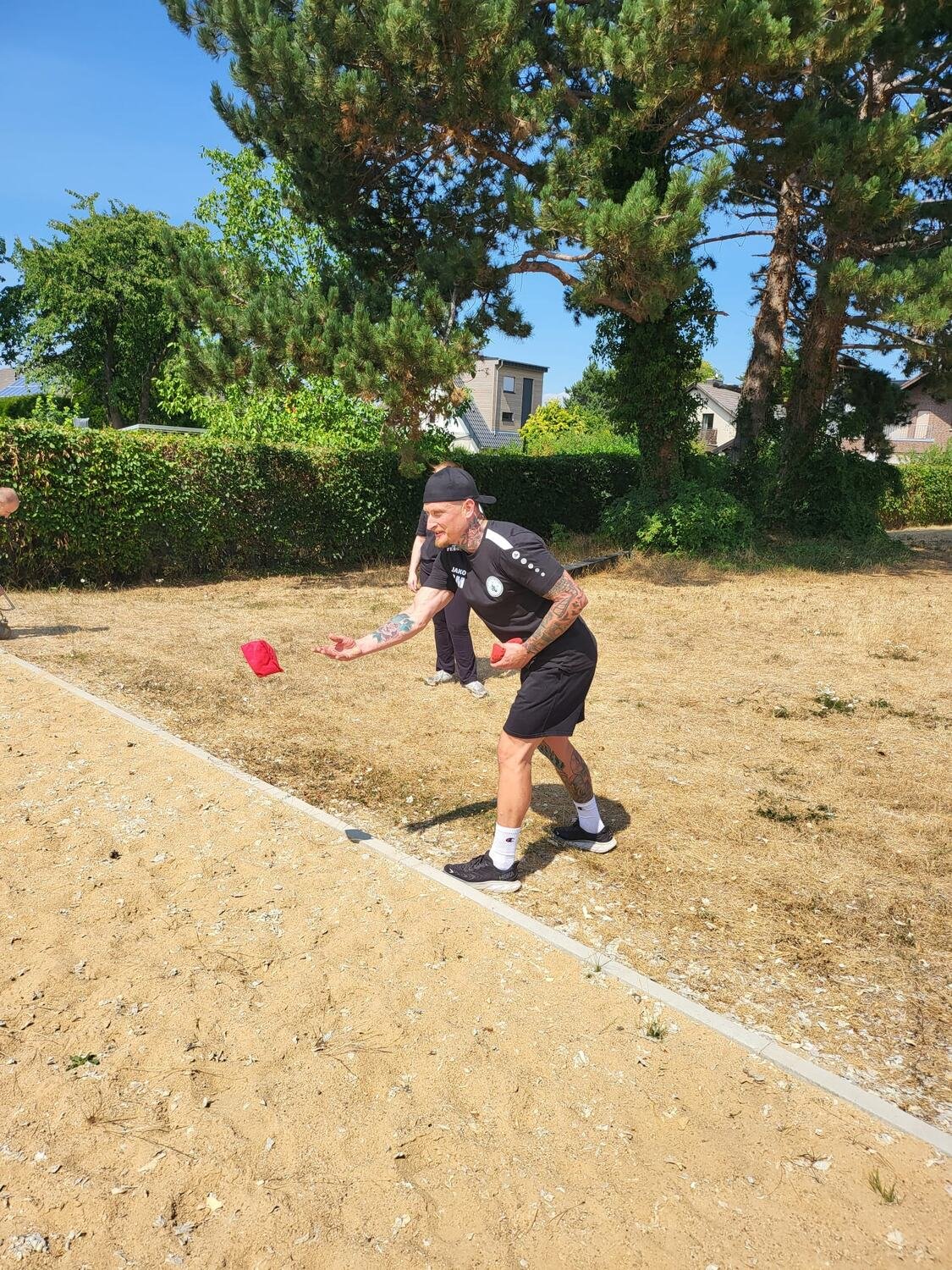 Cornhole — ein Teilnehmer wirft den Beutel in Richtung des Holzbretts