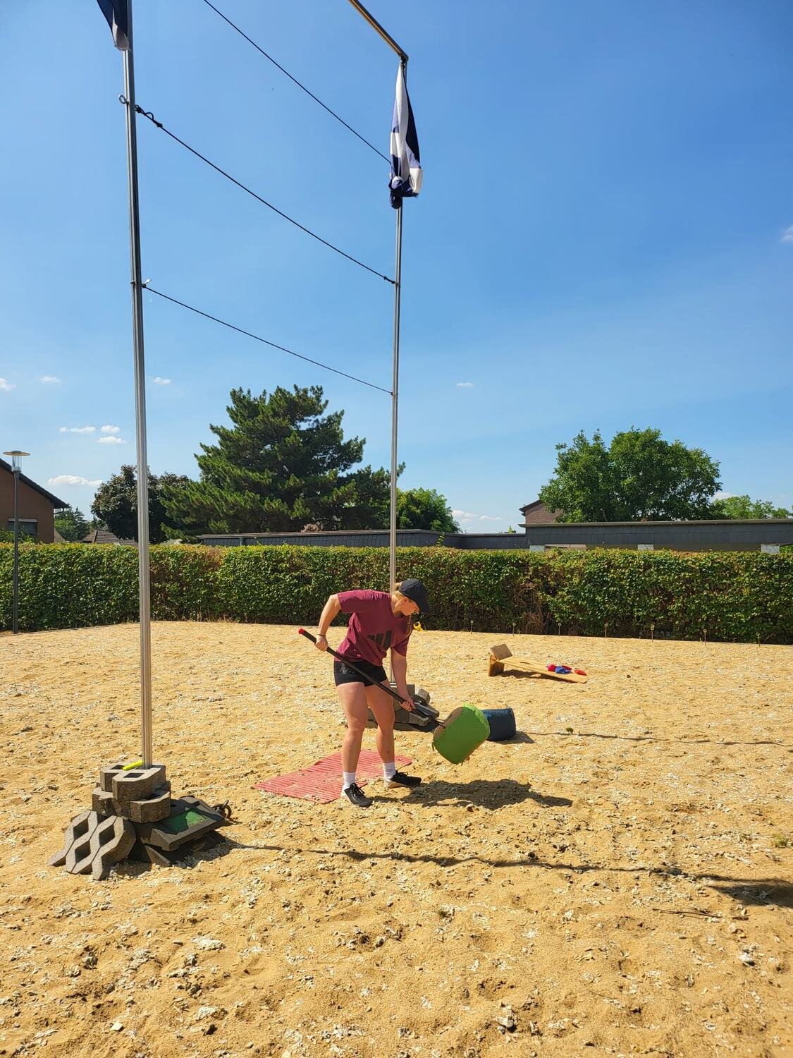Sackwurf mit der Gabel — eine Sportlerin hebt den Sack mit der Wurfgabel Richtung Hochlatte an