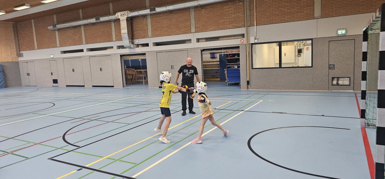Kindertraining — Sparring unter Anleitung des Trainers in der Sporthalle